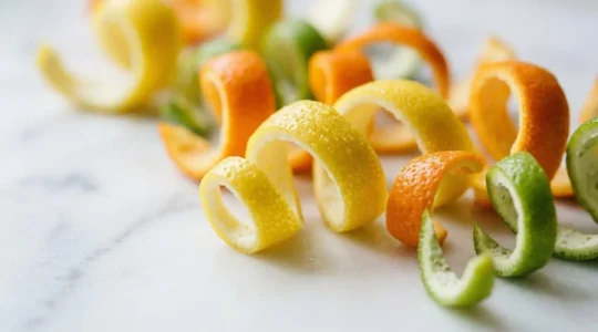 Zestes colorés d'agrumes frais en rubans délicats sur fond clair minimaliste