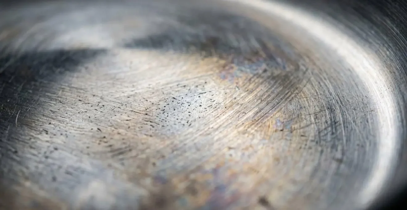 Vue macro détaillée de la surface d'une casserole en acier inoxydable montrant la texture